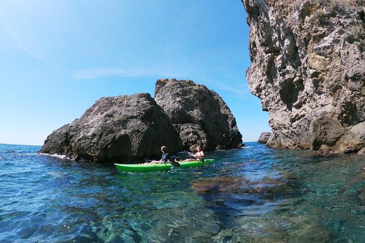 dues persones en un caiac a l'aigua prop d'unes roques