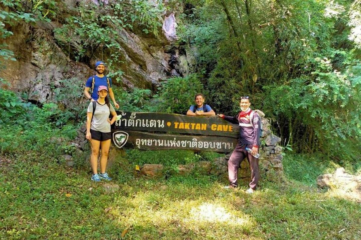 un gruppo di persone in piedi davanti a un cartello
