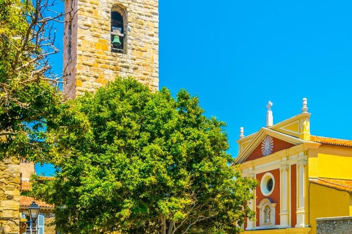 un edificio giallo con una torre e un albero