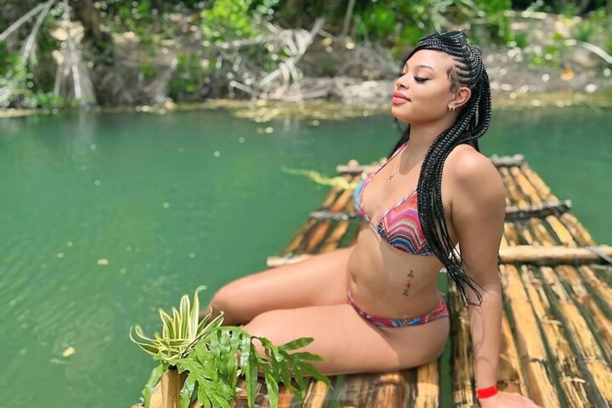 uma mulher de biquíni sentada em uma jangada perto da água