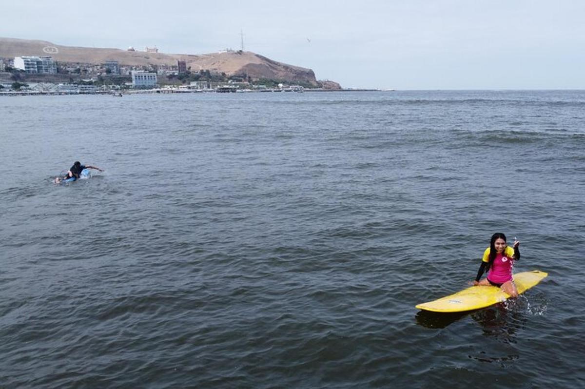 una donna seduta su una tavola da surf in acqua