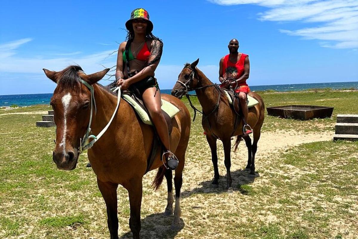 due persone a cavallo sulla spiaggia