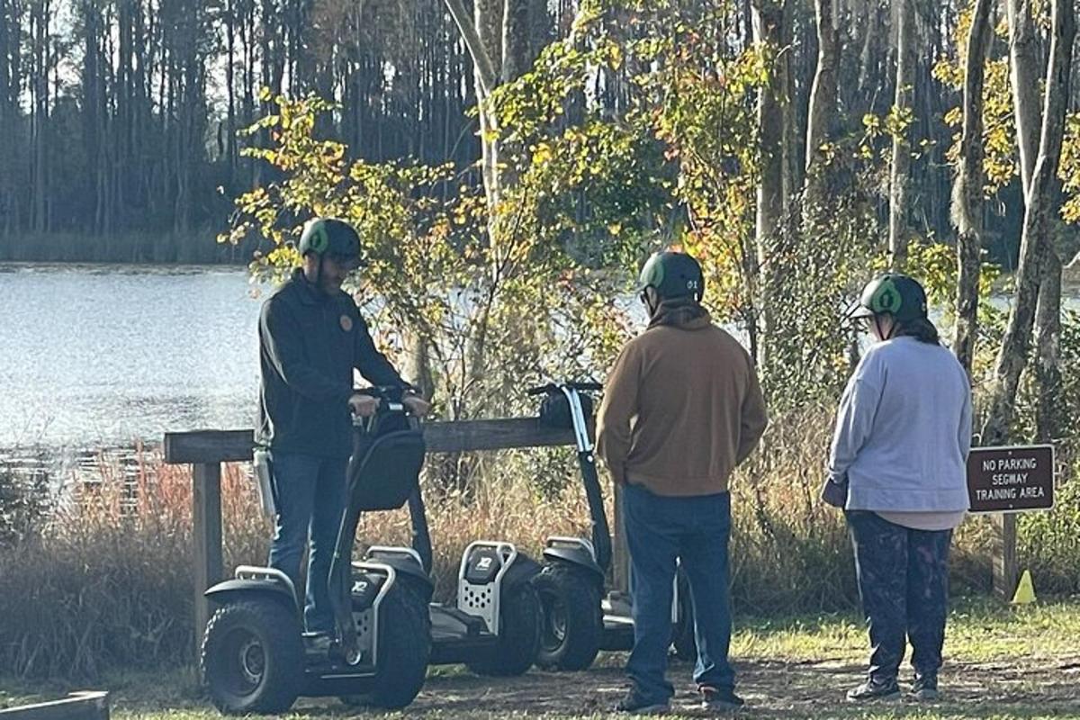 kolmest inimesest koosnev grupp seisab golfikäru ümber