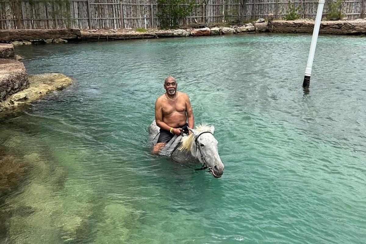 un uomo seduto su un cavallo nell'acqua