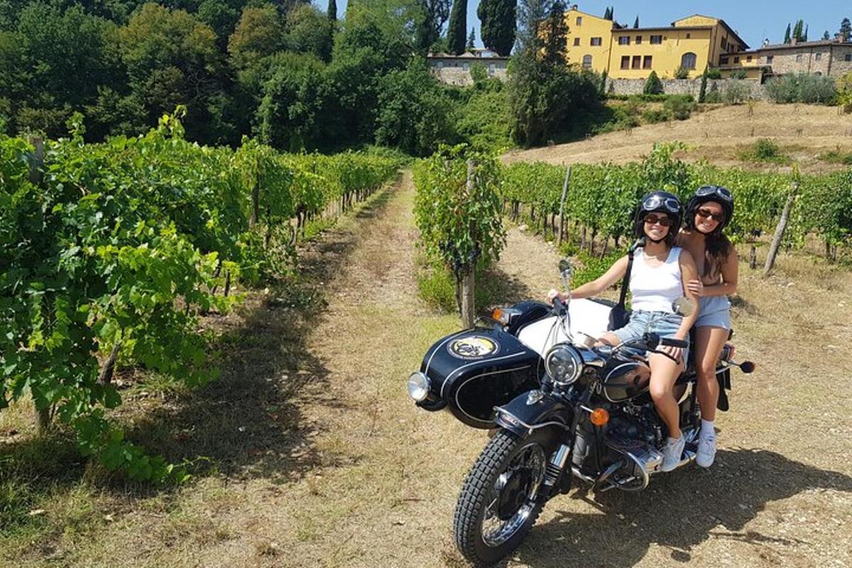 duas meninas estão sentadas em uma motocicleta em um vinhedo