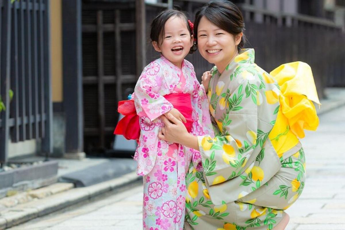 o femeie care ține în brațe o fetiță îmbrăcată într-un kimono