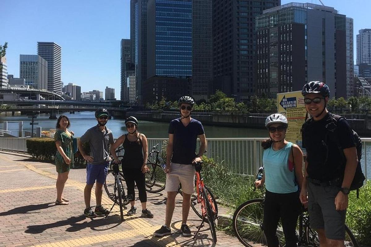 een groep mensen die met fietsen op een brug staan