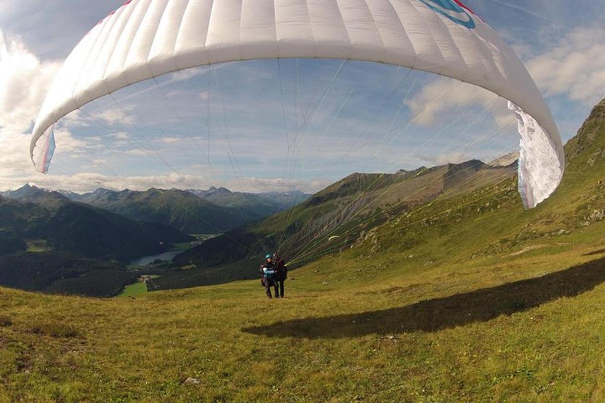 osoba létající s padákem na vrcholu hory