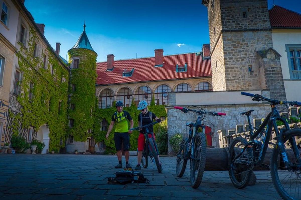 dva lidé stojící před budovou se svými koly