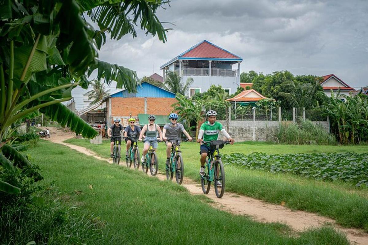 Un grupo de personas andando en bicicleta por un camino de tierra.