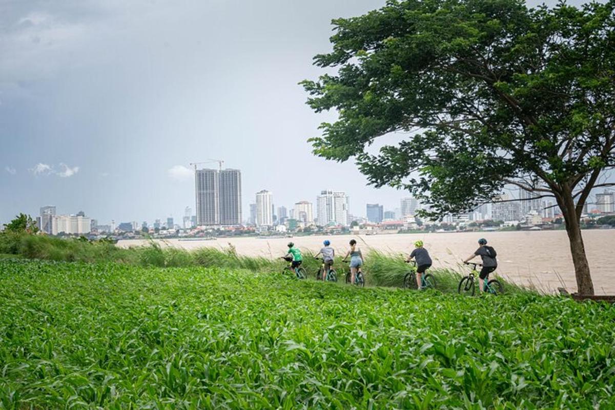 Un grupo de personas bajando en bicicleta por una colina cerca del agua.