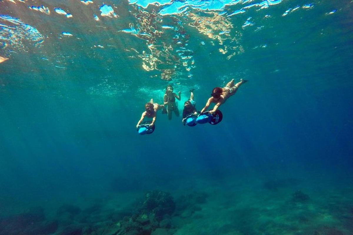 un gruppo di persone che vanno in scooter in acqua