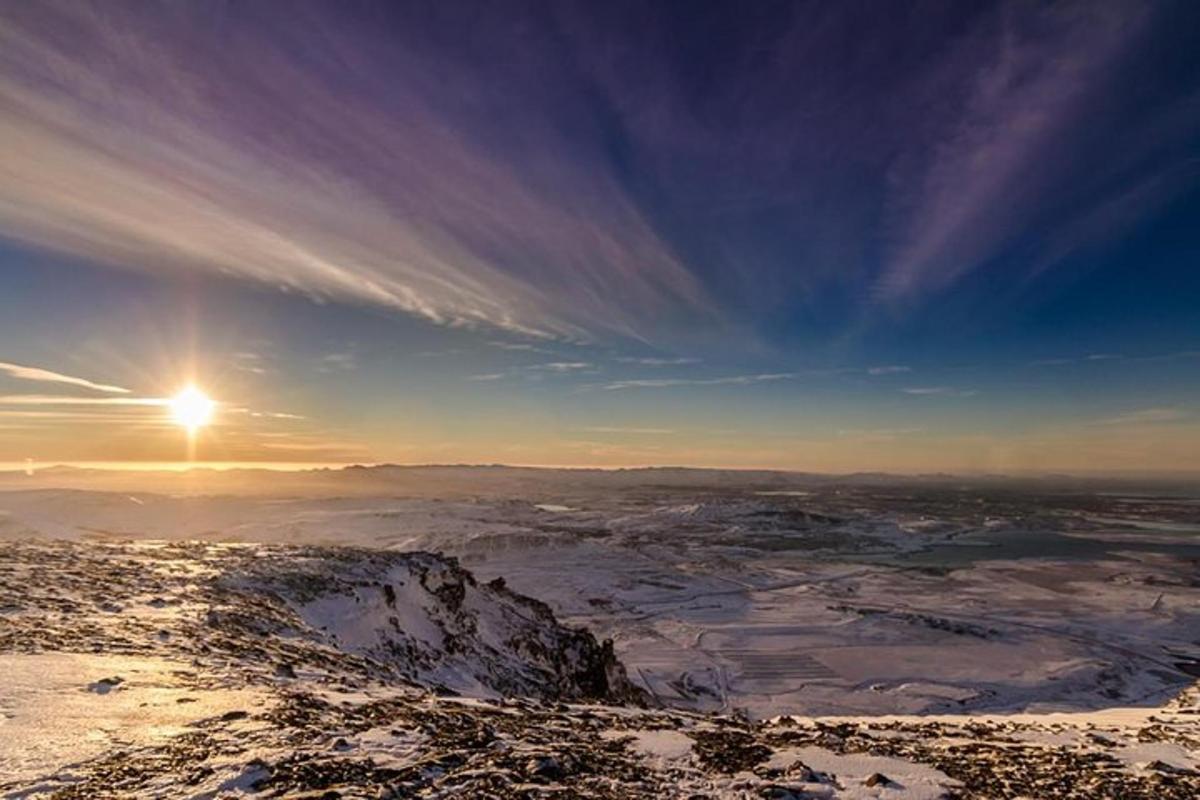 una vista di una montagna innevata con il sole nel cielo