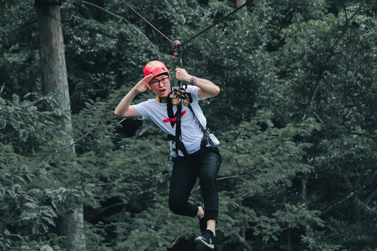 a man on a zip line in the forest