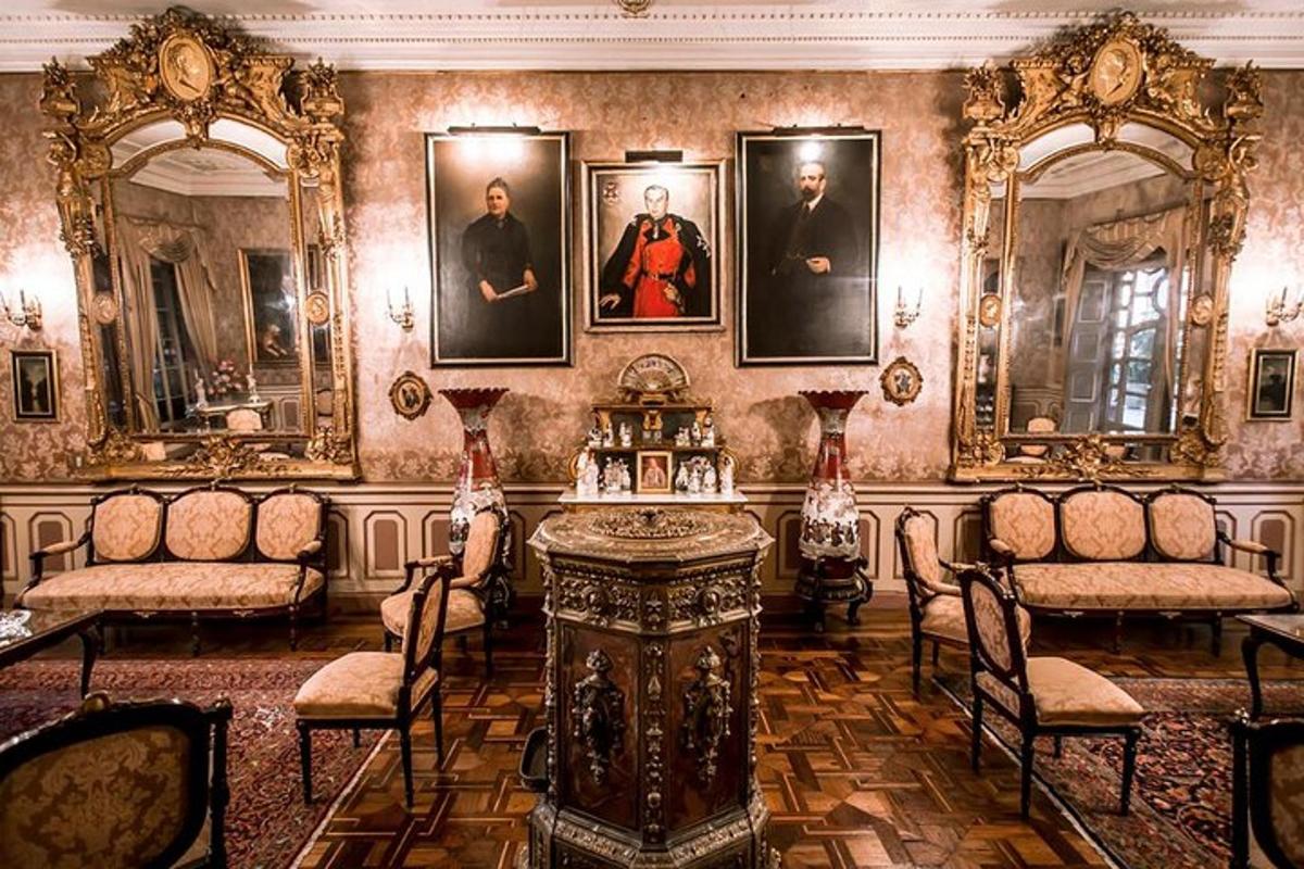 uma sala com retratos nas paredes e uma mesa e cadeiras