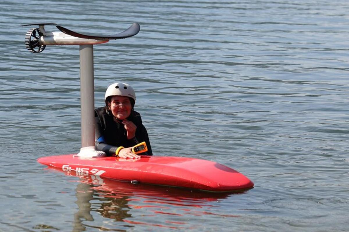 een persoon die op een rood paddleboard in het water zit