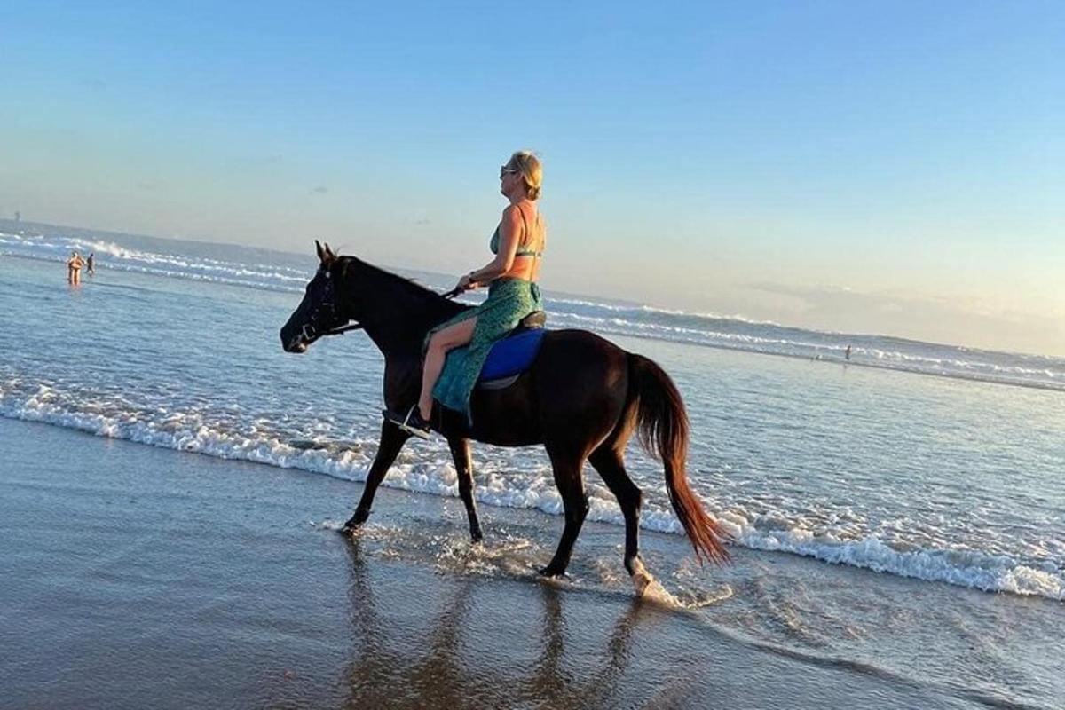 a young girl riding a horse on the beach