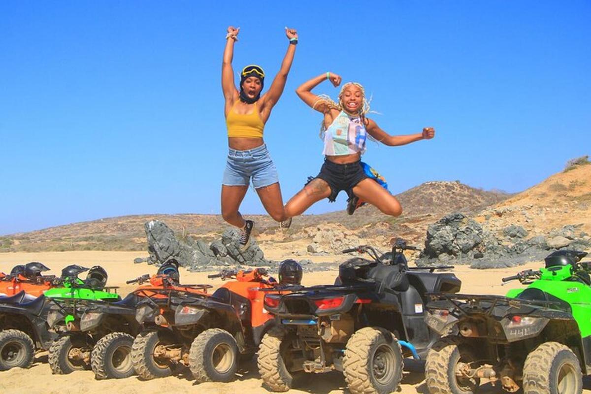 Dos mujeres saltando en el aire sobre vehículos todo terreno en la playa