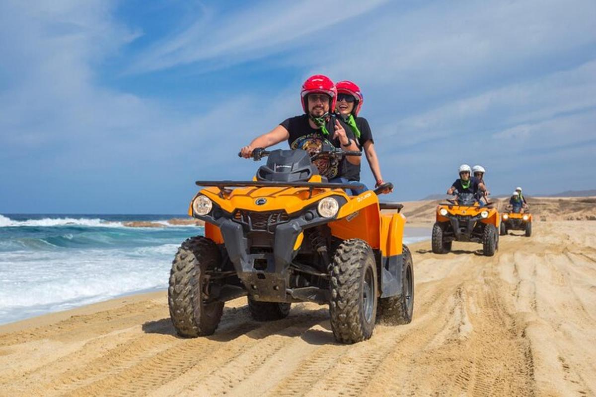 Un grupo de personas conduciendo vehículos todo terreno en la playa.