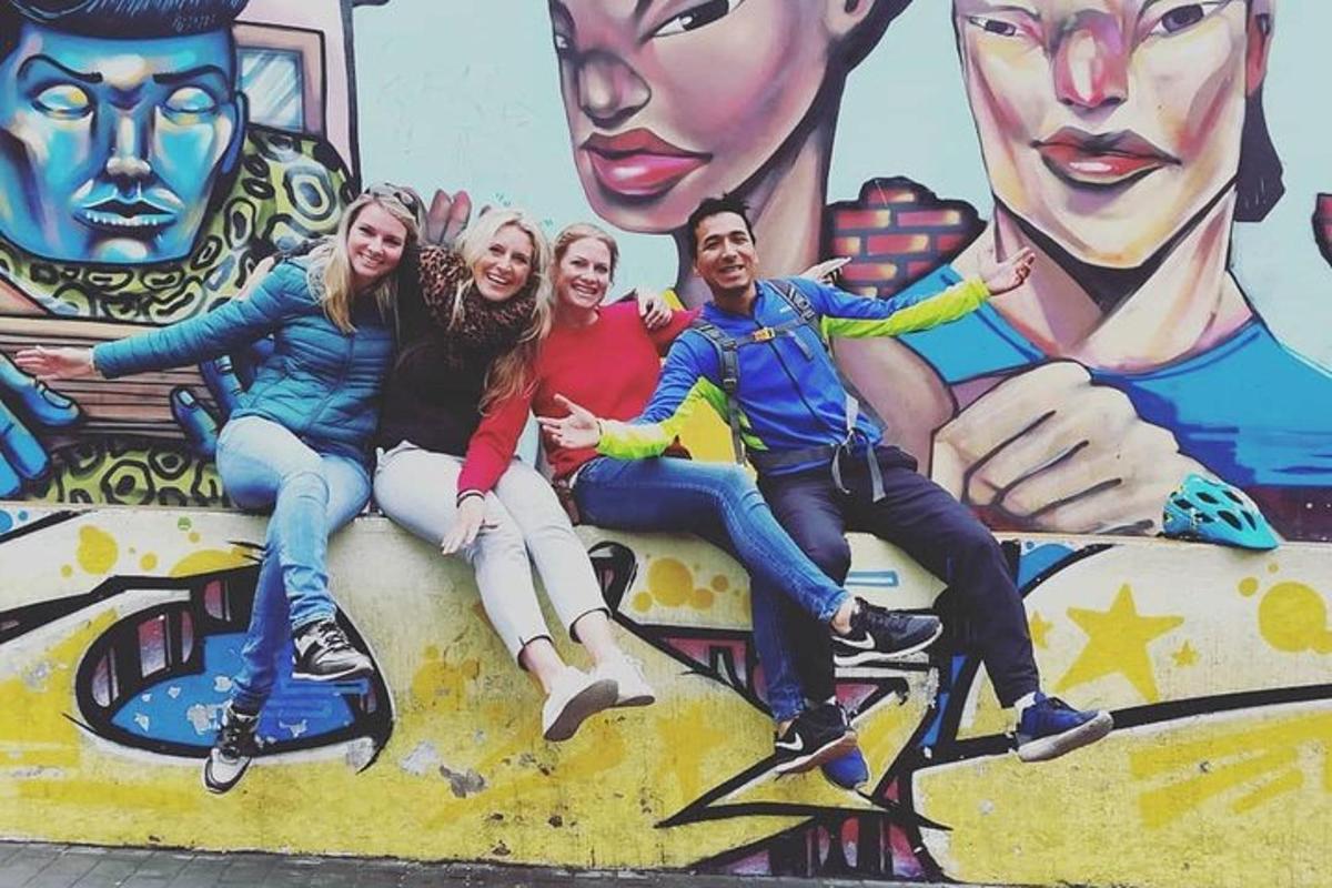 un grup de oameni așezați pe un perete în fața unei picturi murale