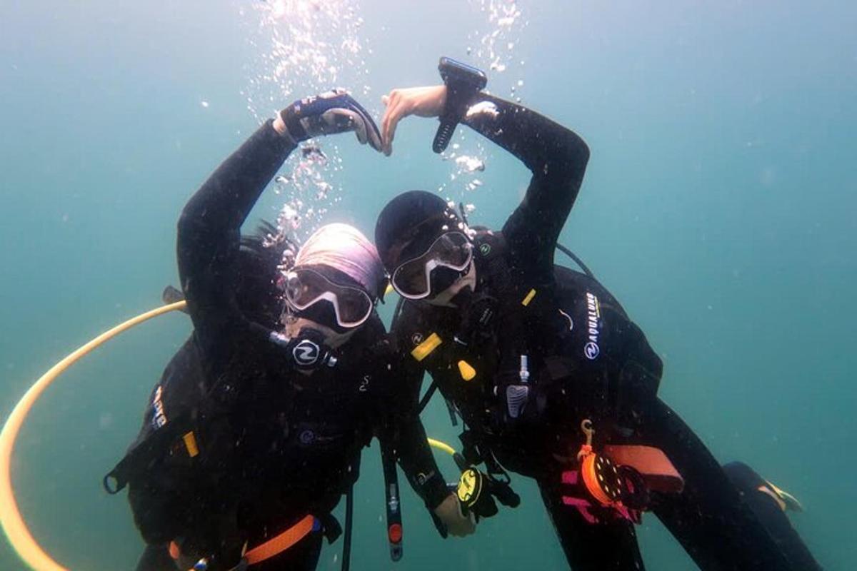 two people are making a heart shape in the water