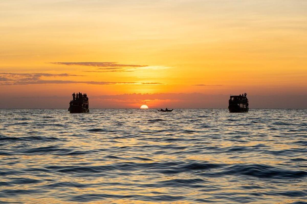 Západ slunce nad oceánem s kameny ve vodě