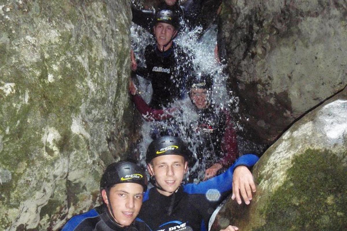 a group of people in a cave in a waterfall