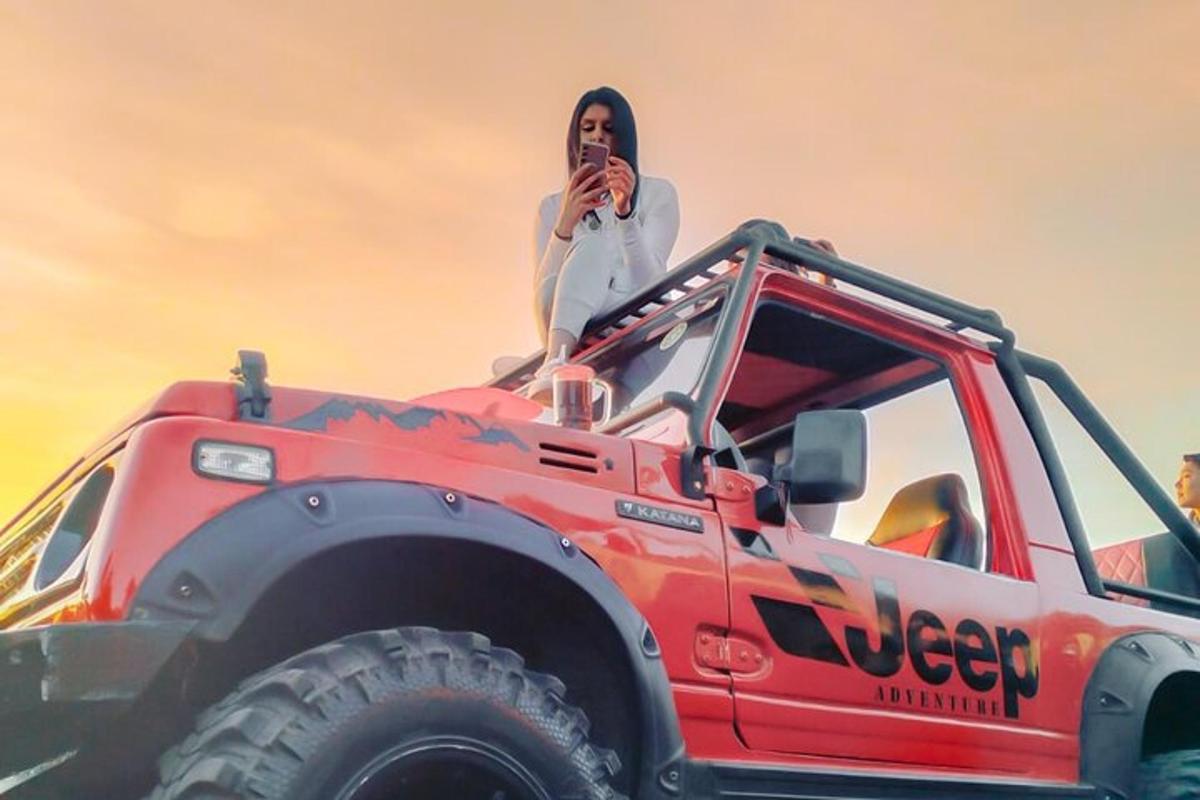 una donna seduta sul retro di una jeep rossa
