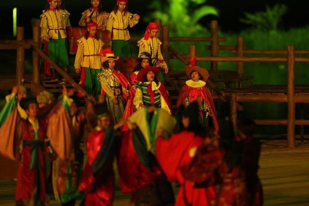 กลุ่มคนในชุดสีสันสดใสยืนอยู่รอบๆ