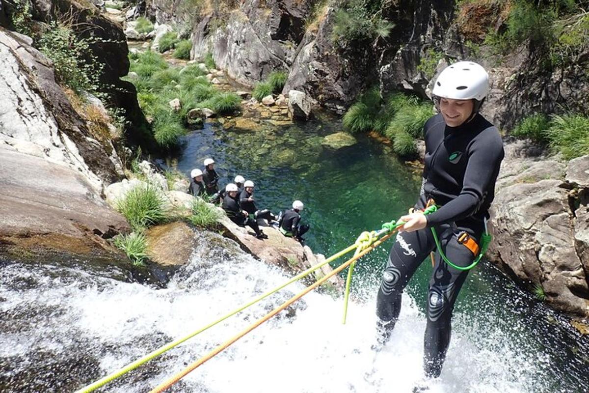 um homem está atravessando um rio em uma ponte de corda