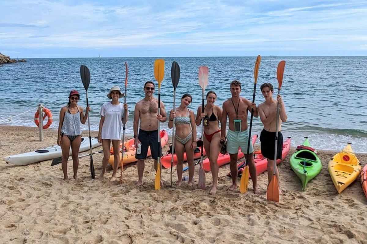 un gruppo di persone in piedi su una spiaggia con i kayak