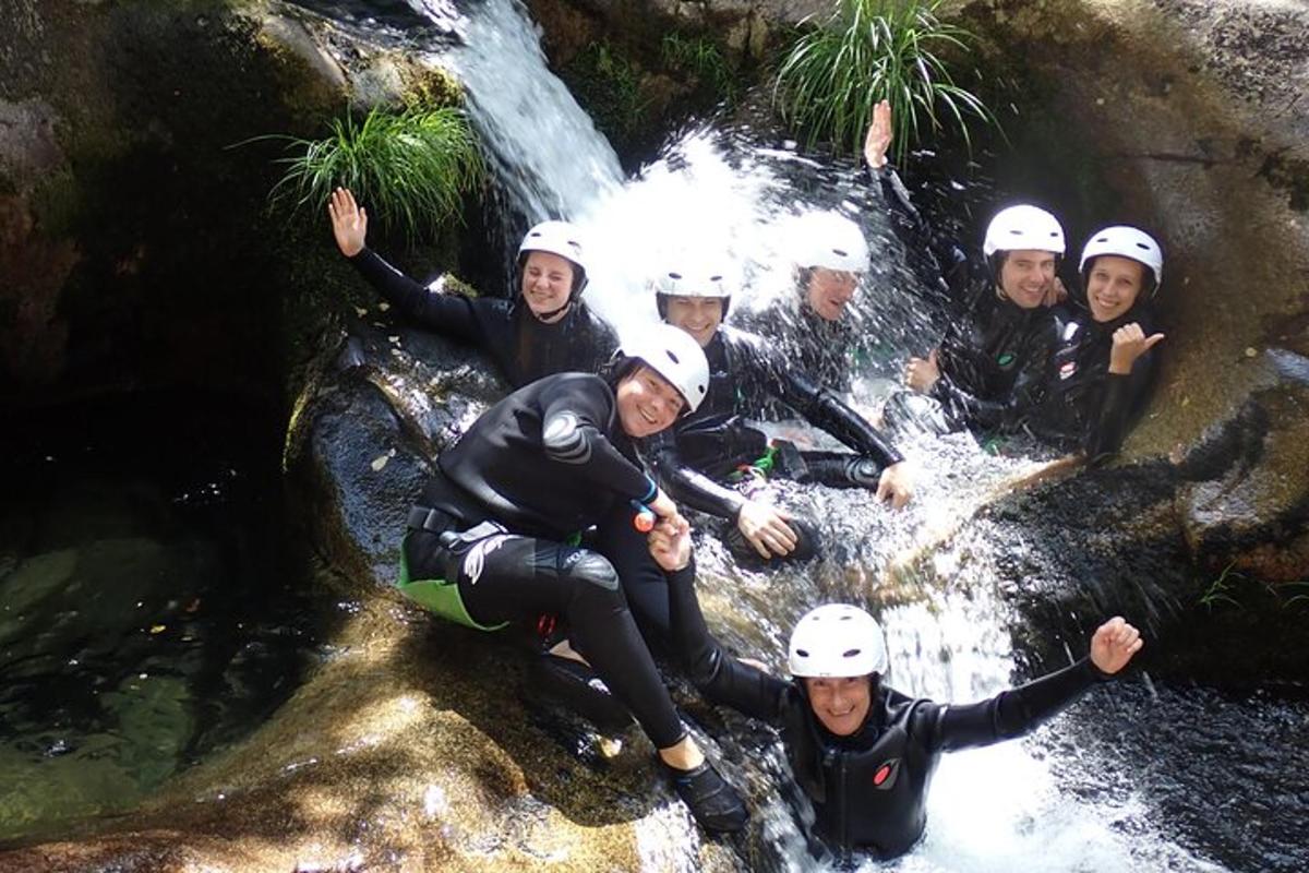um grupo de pessoas posando em frente a uma cachoeira