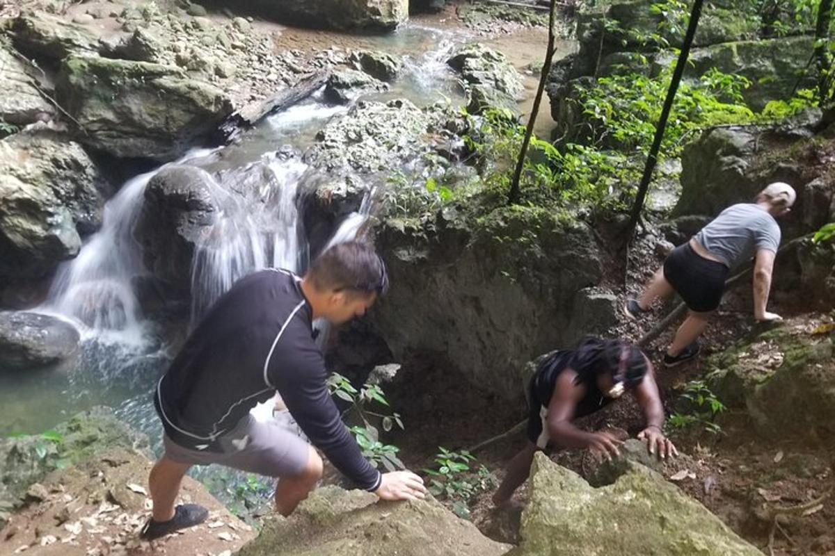 eine Gruppe von Menschen steht auf Felsen in der Nähe eines Wasserfalls