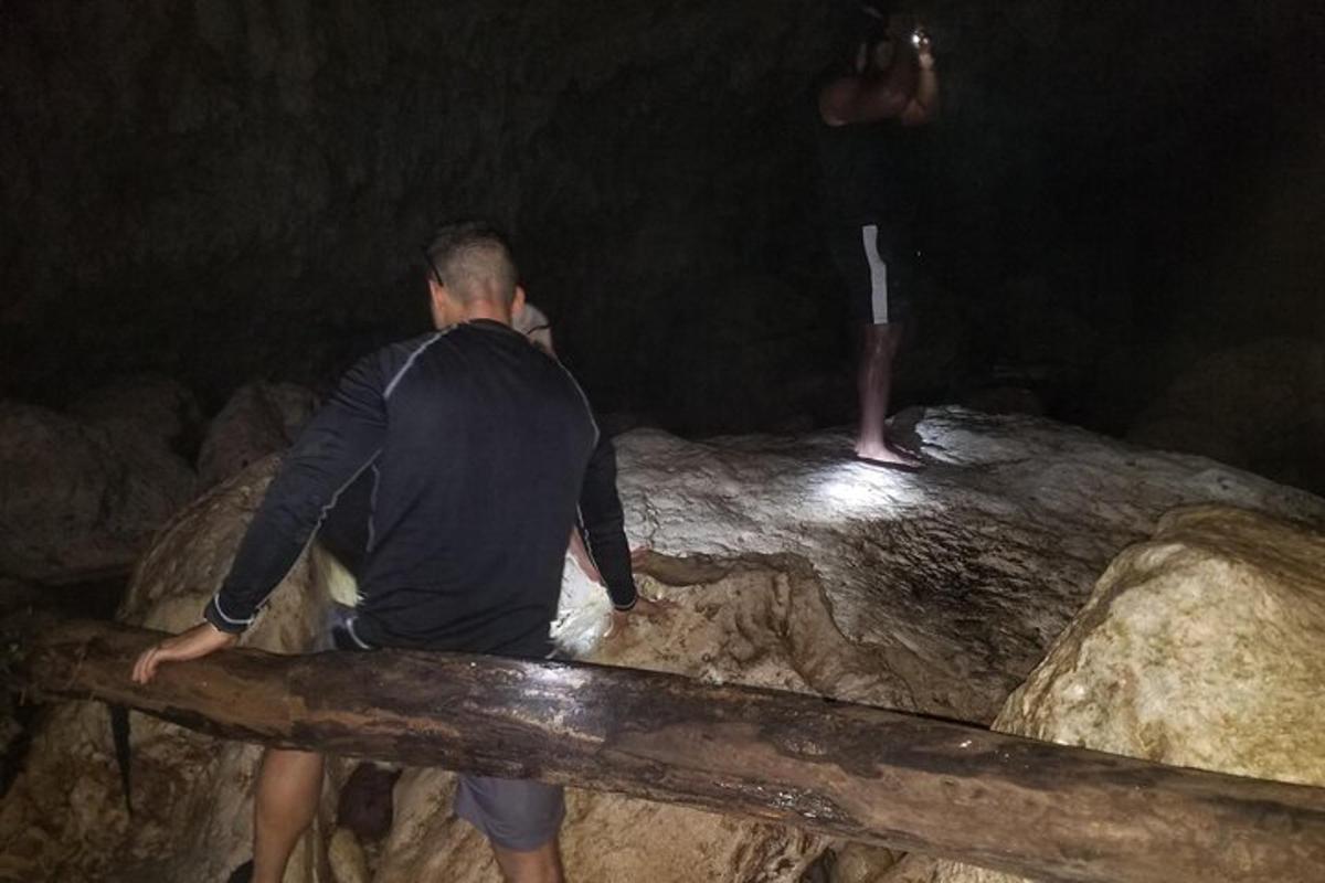 Ein Mann steht auf einem Felsen und schaut auf einen Mann auf einem Stock