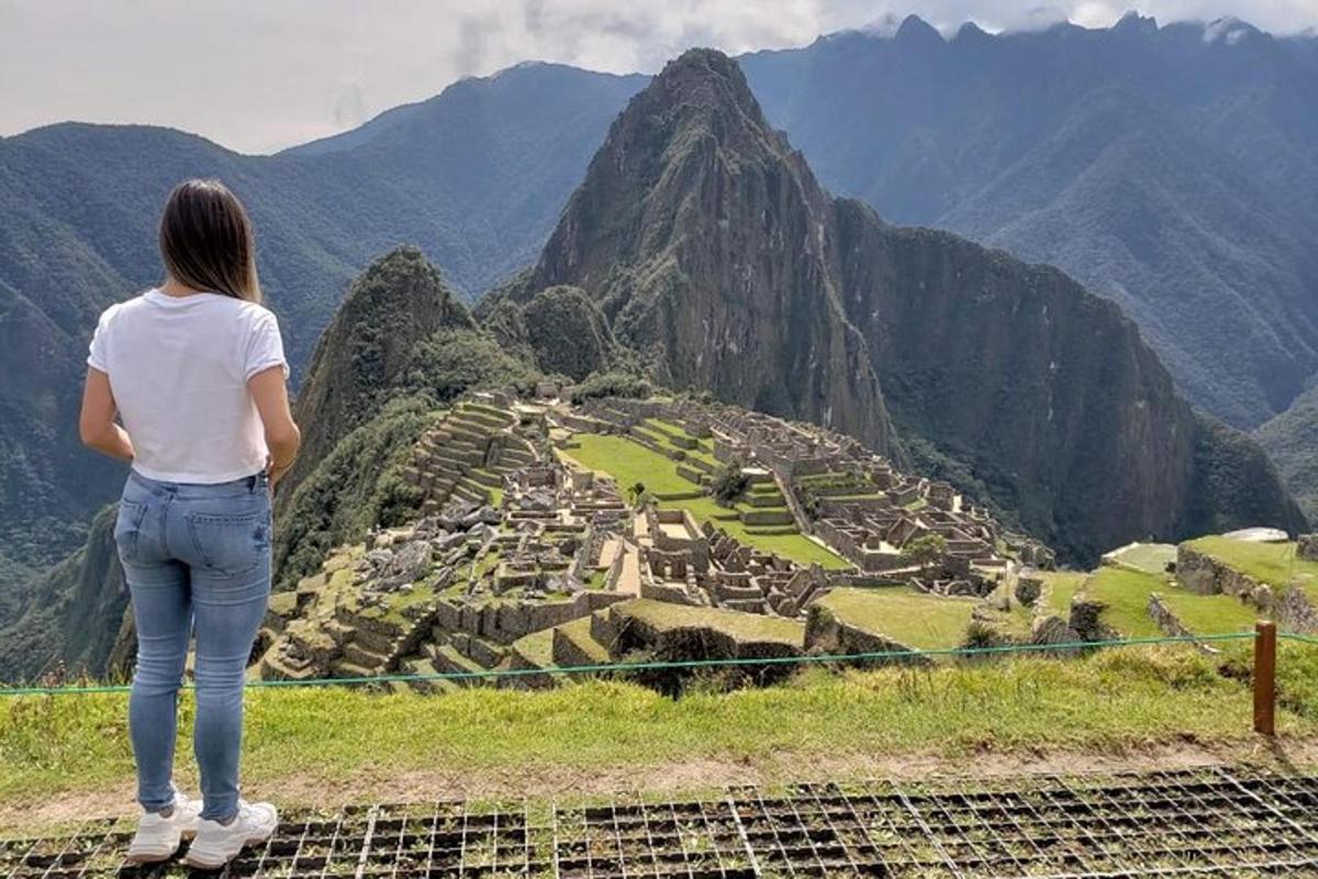 Una mujer parada en la cima de una montaña mirando una ciudad.