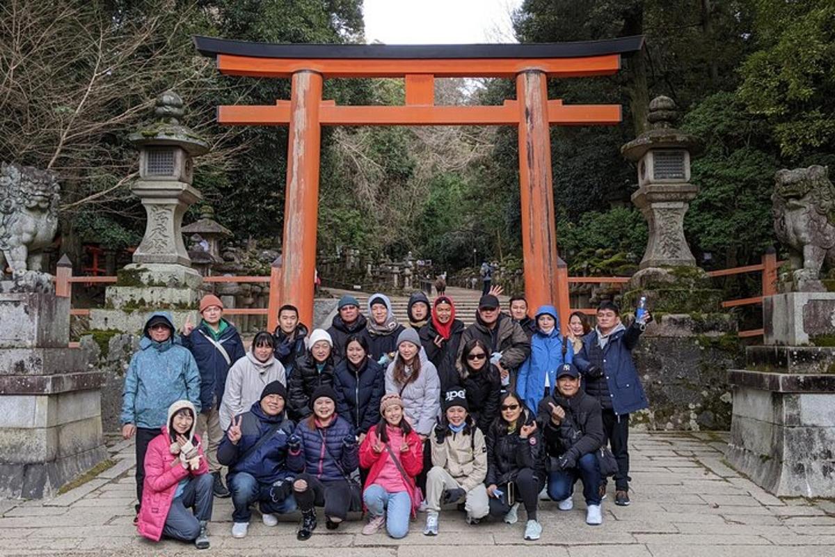 cilvēku grupa pozē torii vārtu priekšā