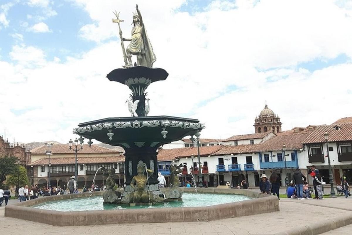 Una fuente con una estatua de una mujer sentada encima.