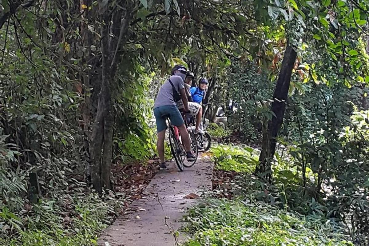 dua orang mengendarai sepeda menyusuri jalan setapak