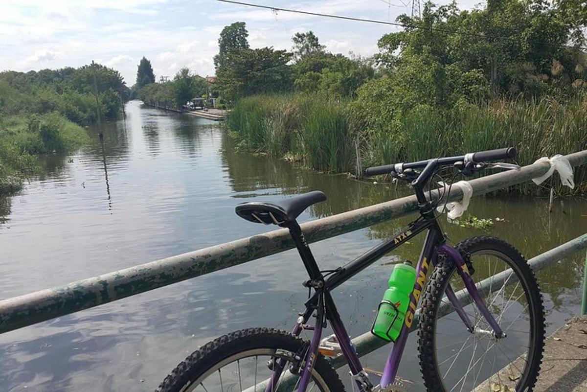 sepeda yang diparkir di rel di samping sungai