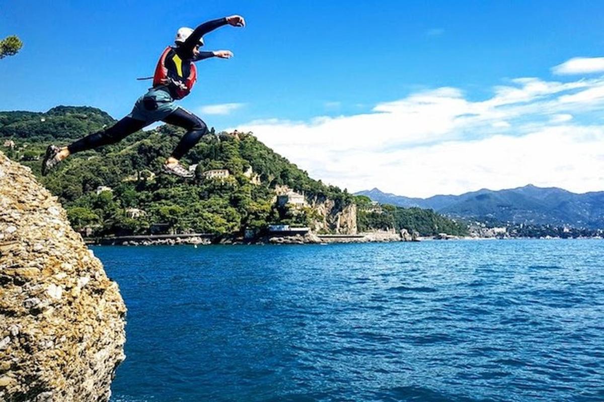 una persona che salta da una scogliera in uno specchio d'acqua