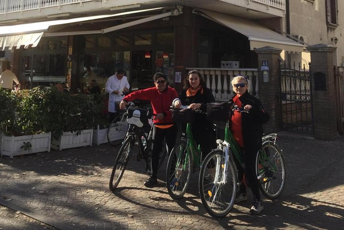 tres persones dempeus amb les seves bicicletes al carrer