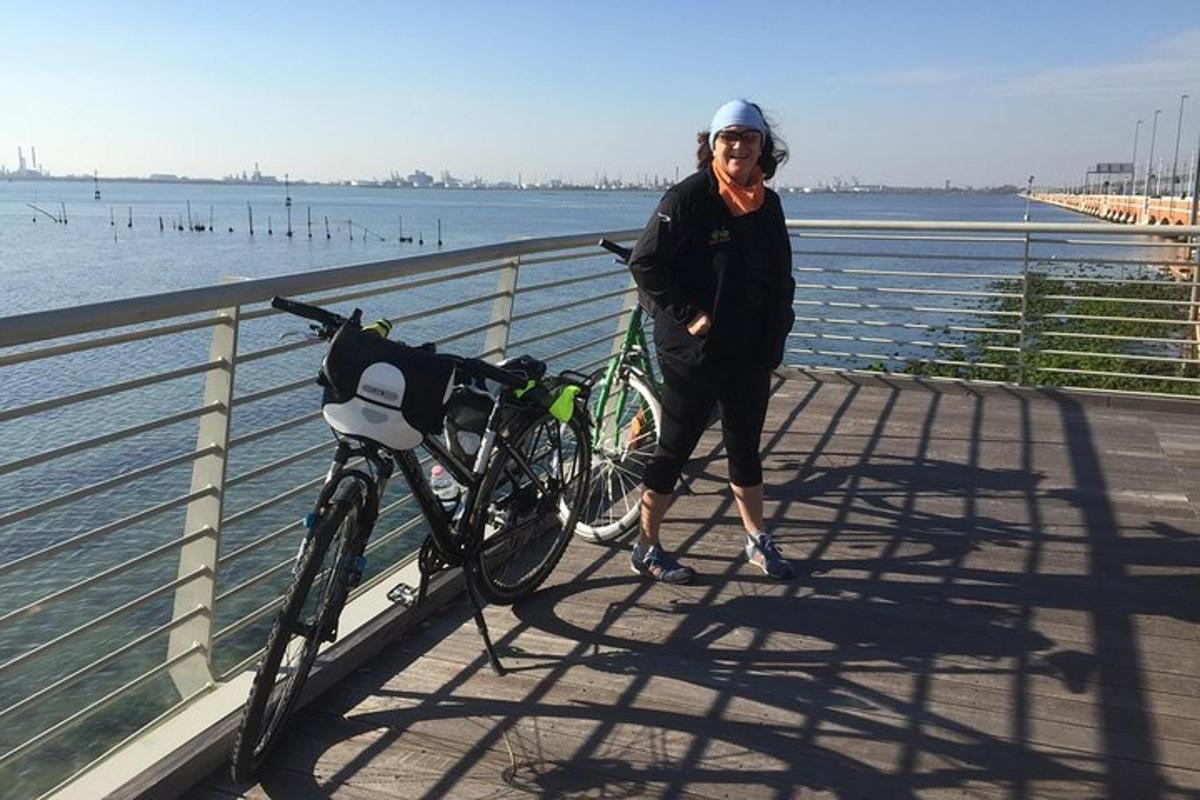 una dona dreta al costat d'una bicicleta en un pont