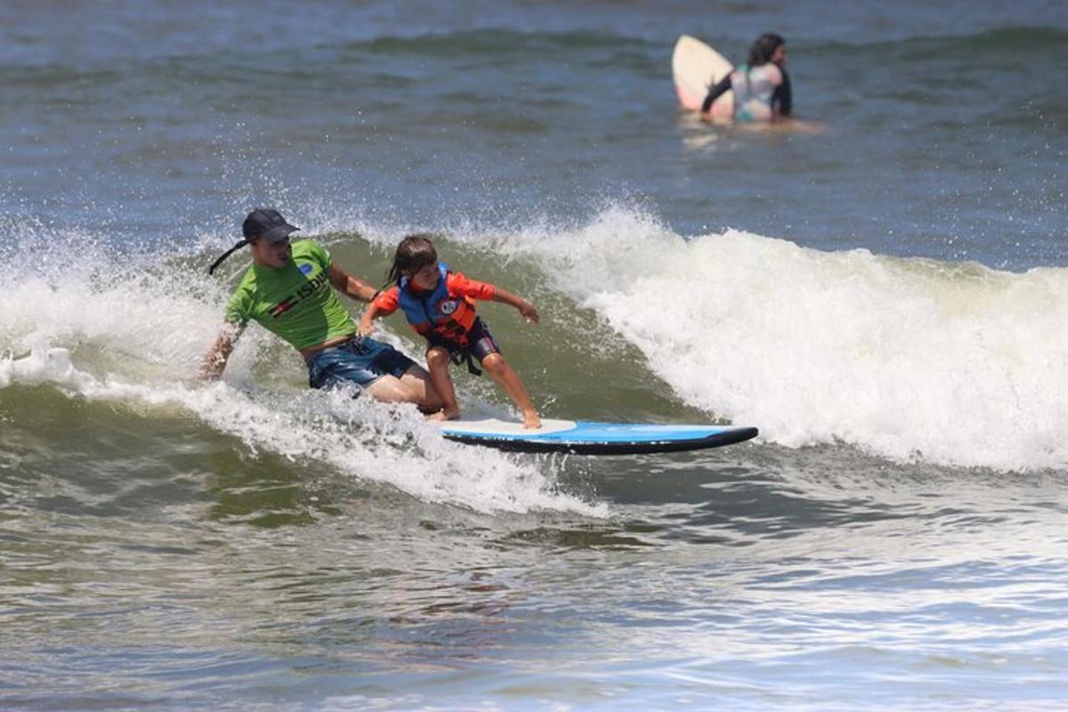 duas pessoas pegando uma onda em uma prancha de surfe no oceano