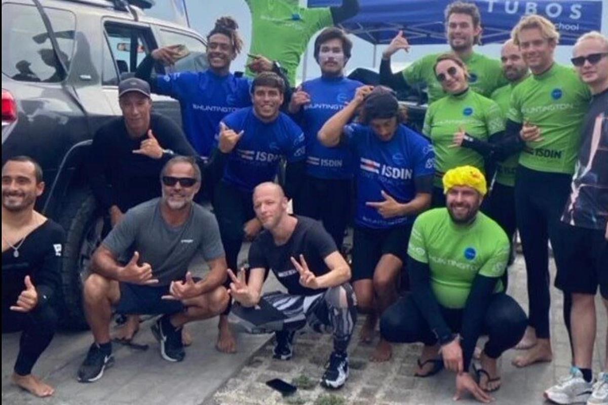um grupo de homens posando para uma foto na frente de um carro