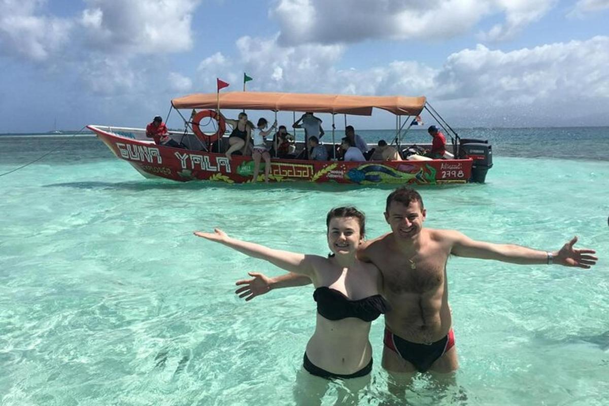 duas pessoas na água em frente a um barco