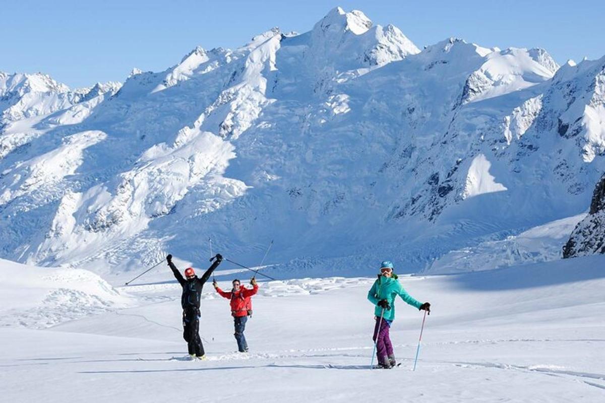 tre personer står på toppen av et snødekt fjell