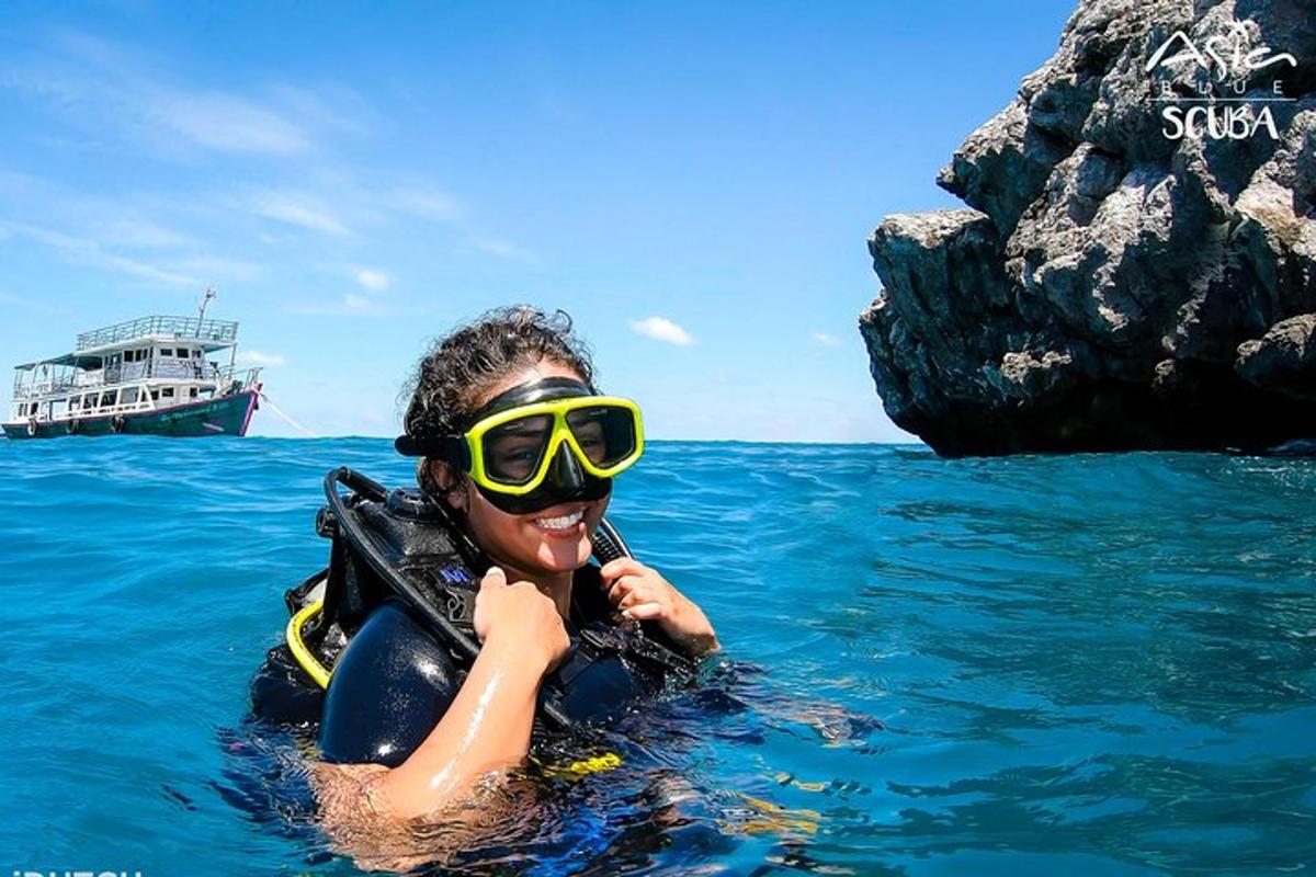 una donna che indossa occhiali da sole in acqua con una barca
