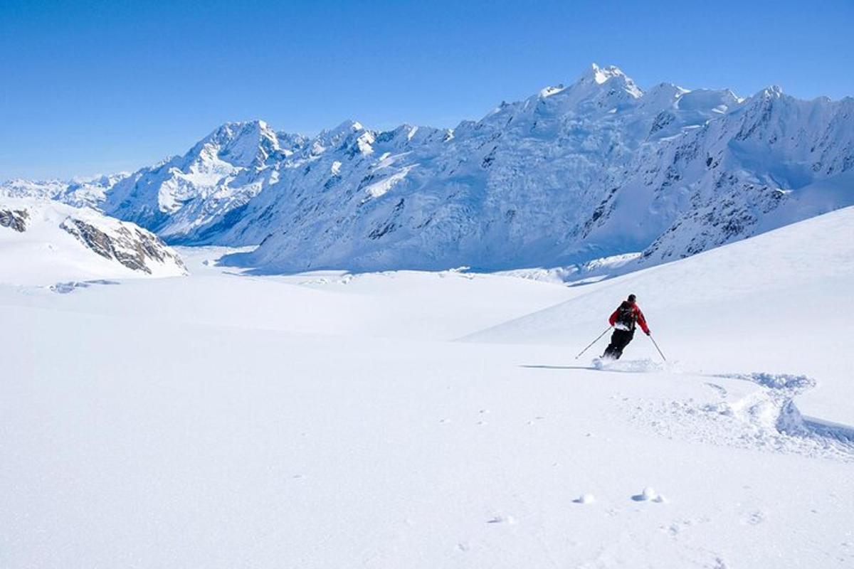 en person står på ski ned et snødekt fjell