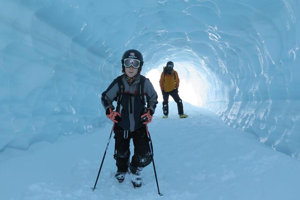 Dos personas con esquís en una cueva de hielo