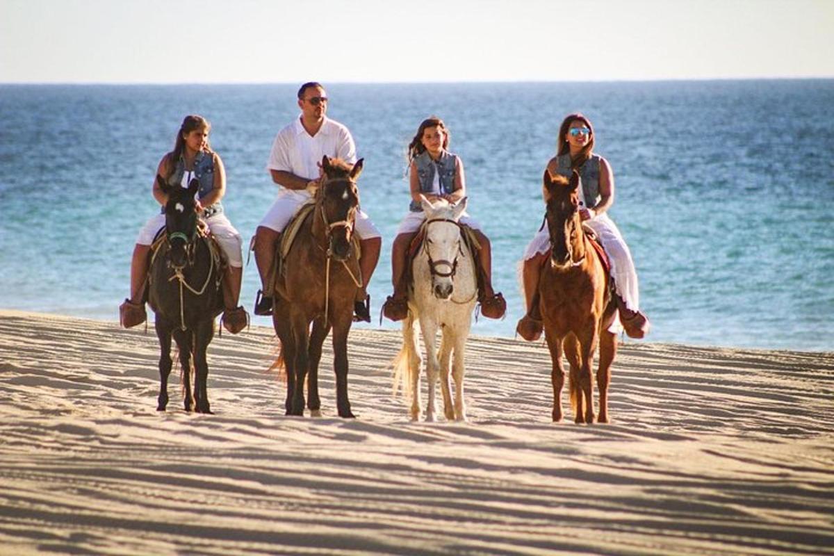 un gruppo di persone a cavallo sulla spiaggia